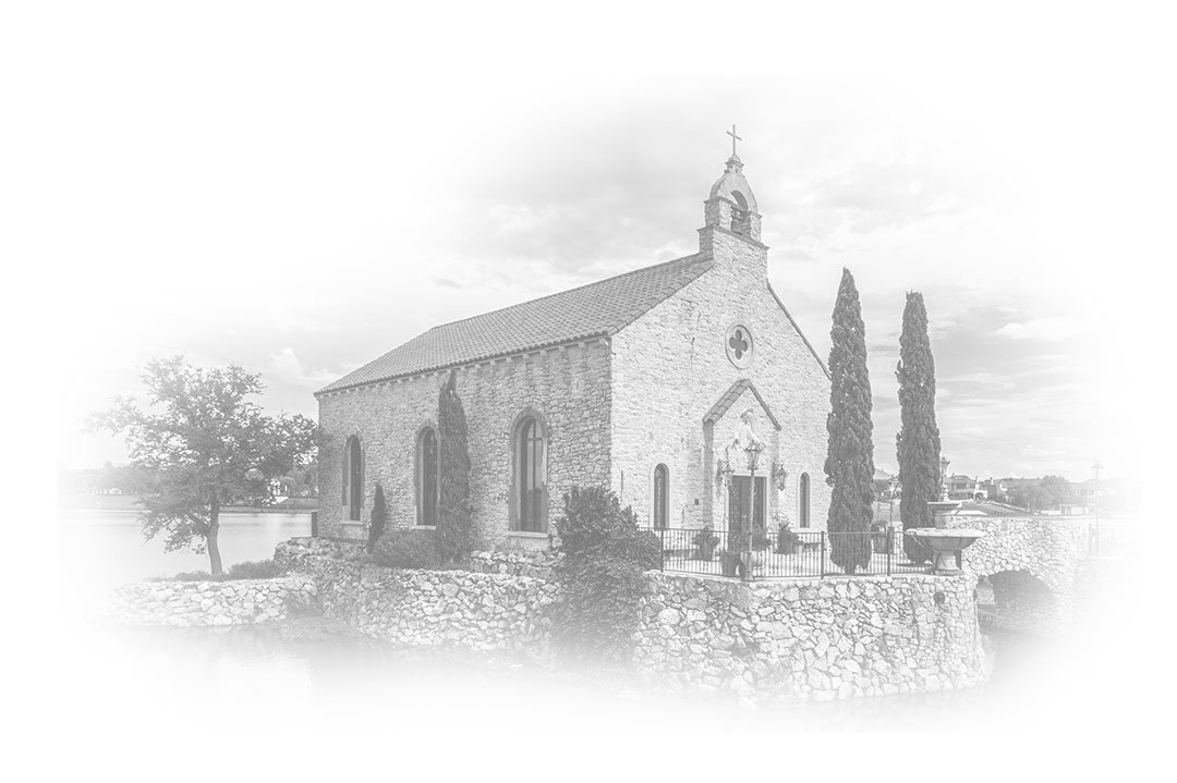 Black and white image of a stone chapel with arched windows and a bell tower, situated on a raised stone platform surrounded by trees and water.